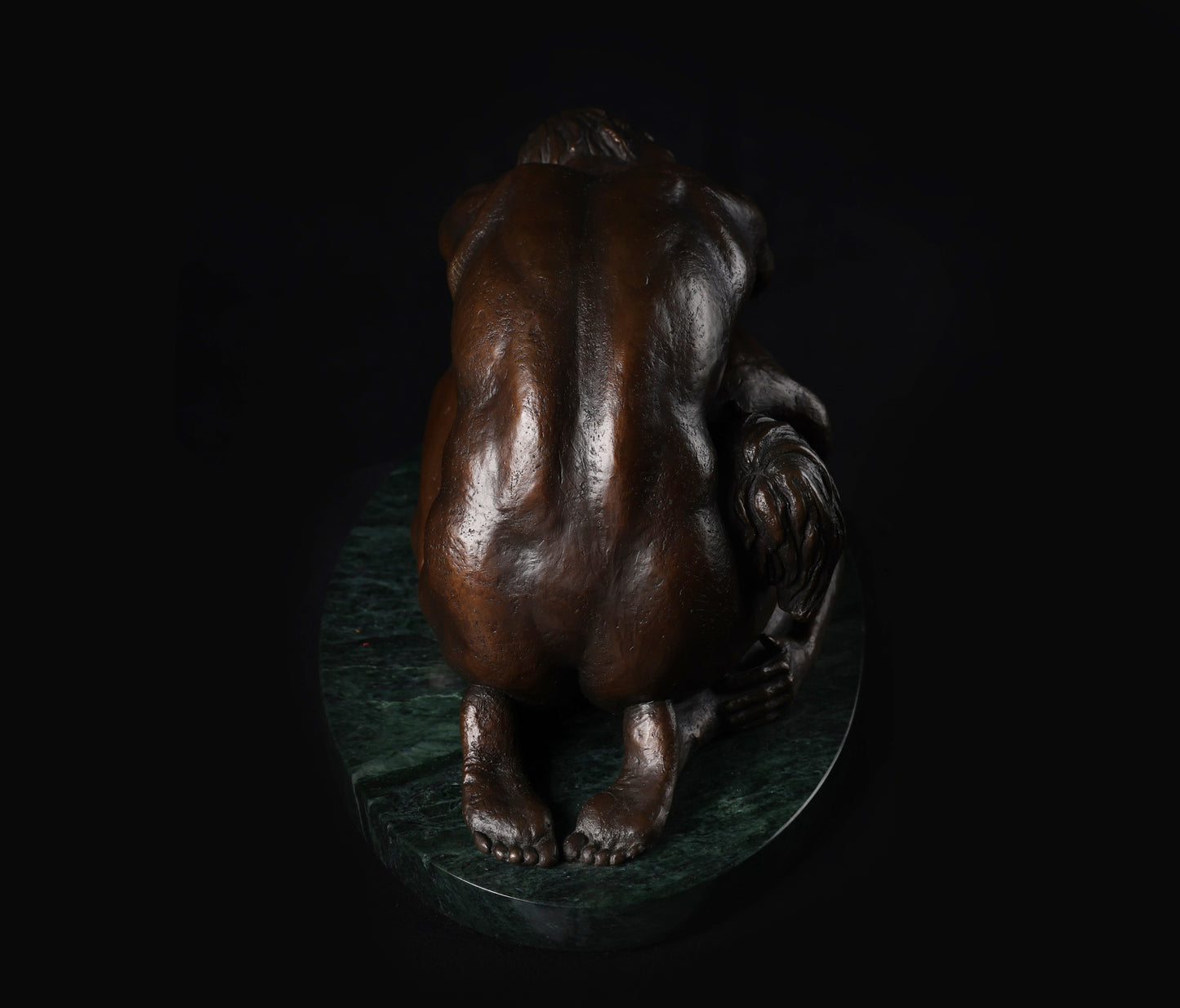 Bronze sculpture of a bear on a dark background