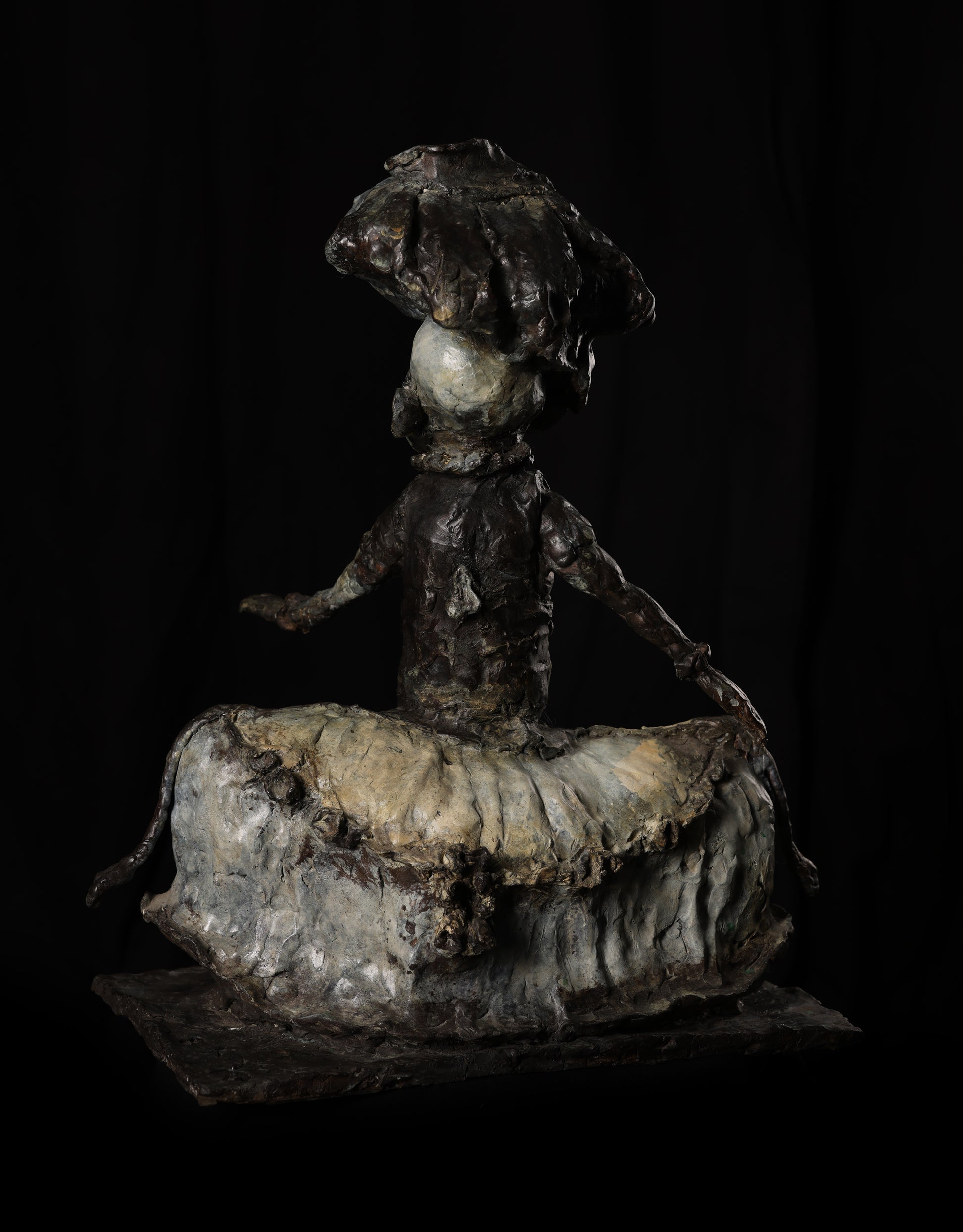 Bronze sculpture of a figure with a dark background