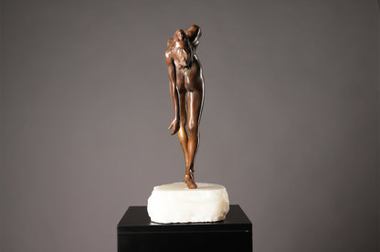 Bronze sculpture of a dancer on a marble base against a gray background