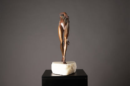 Bronze sculpture of a nude figure on a marble base against a gray background