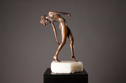 Bronze sculpture of a nude figure on a gray background