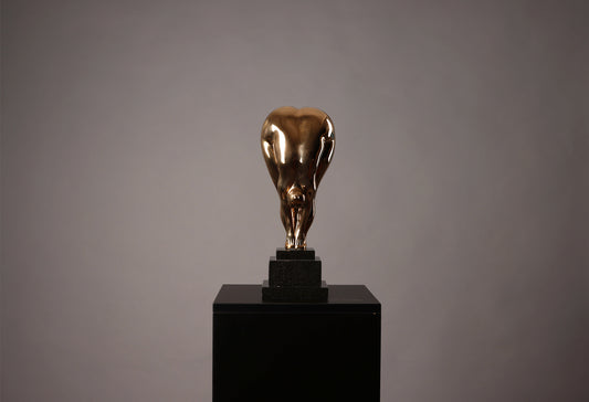 Bronze sculpture of a bull on a black pedestal against a gray background