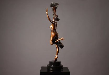 Bronze sculpture of a dancer holding a rock on a gray background