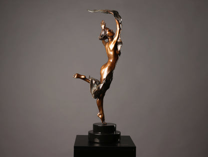 Bronze sculpture of a dancer on a black base against a gray background