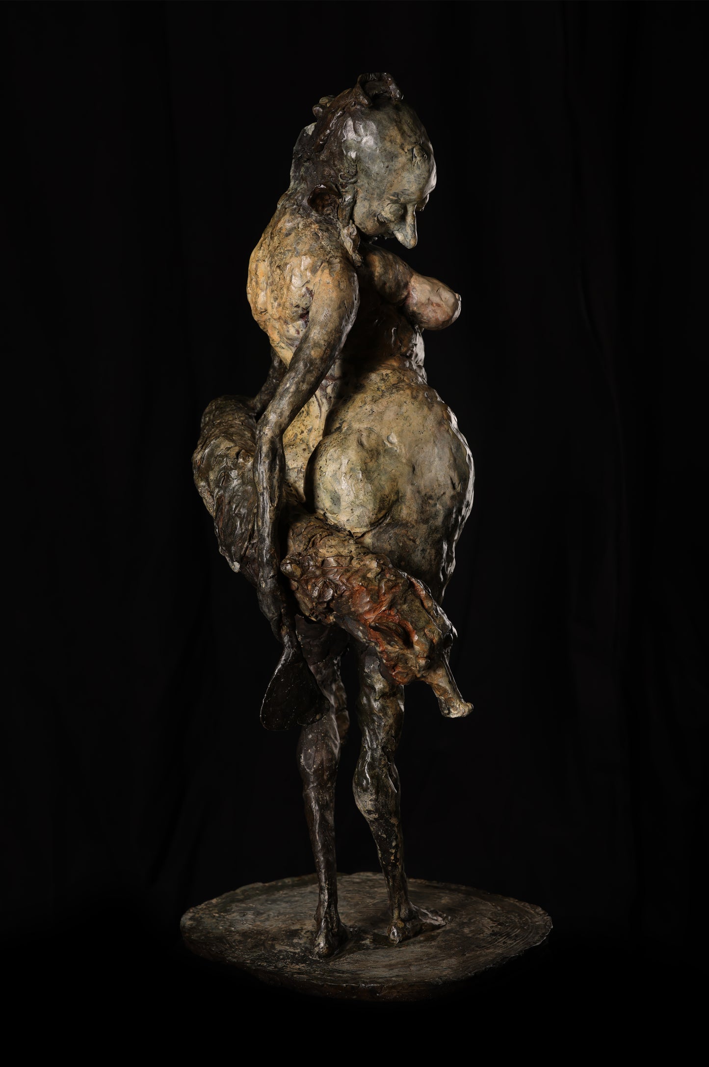 Bronze sculpture of a figure with a horse on a black background