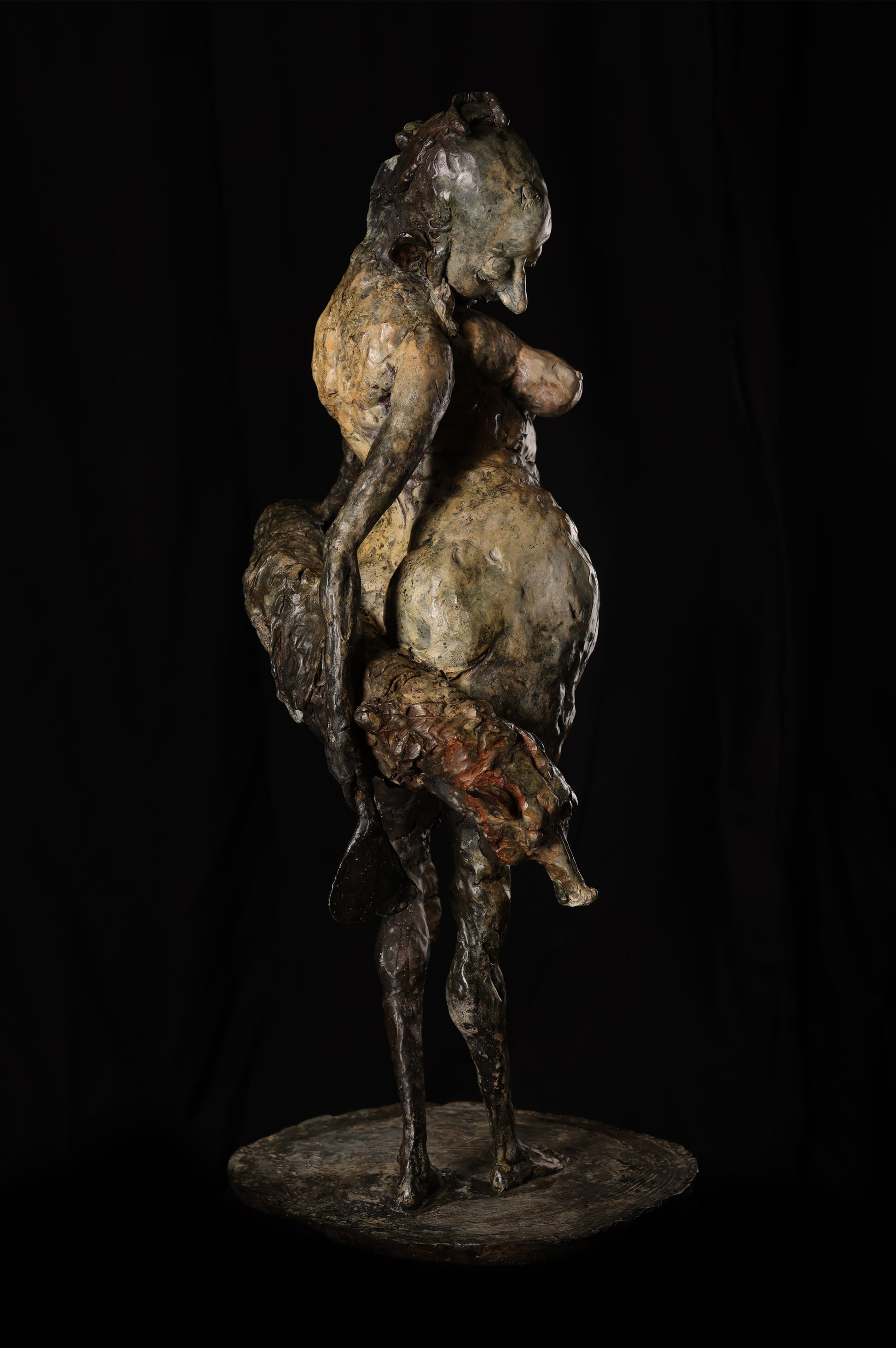 Bronze sculpture of a figure with a horse on a black background