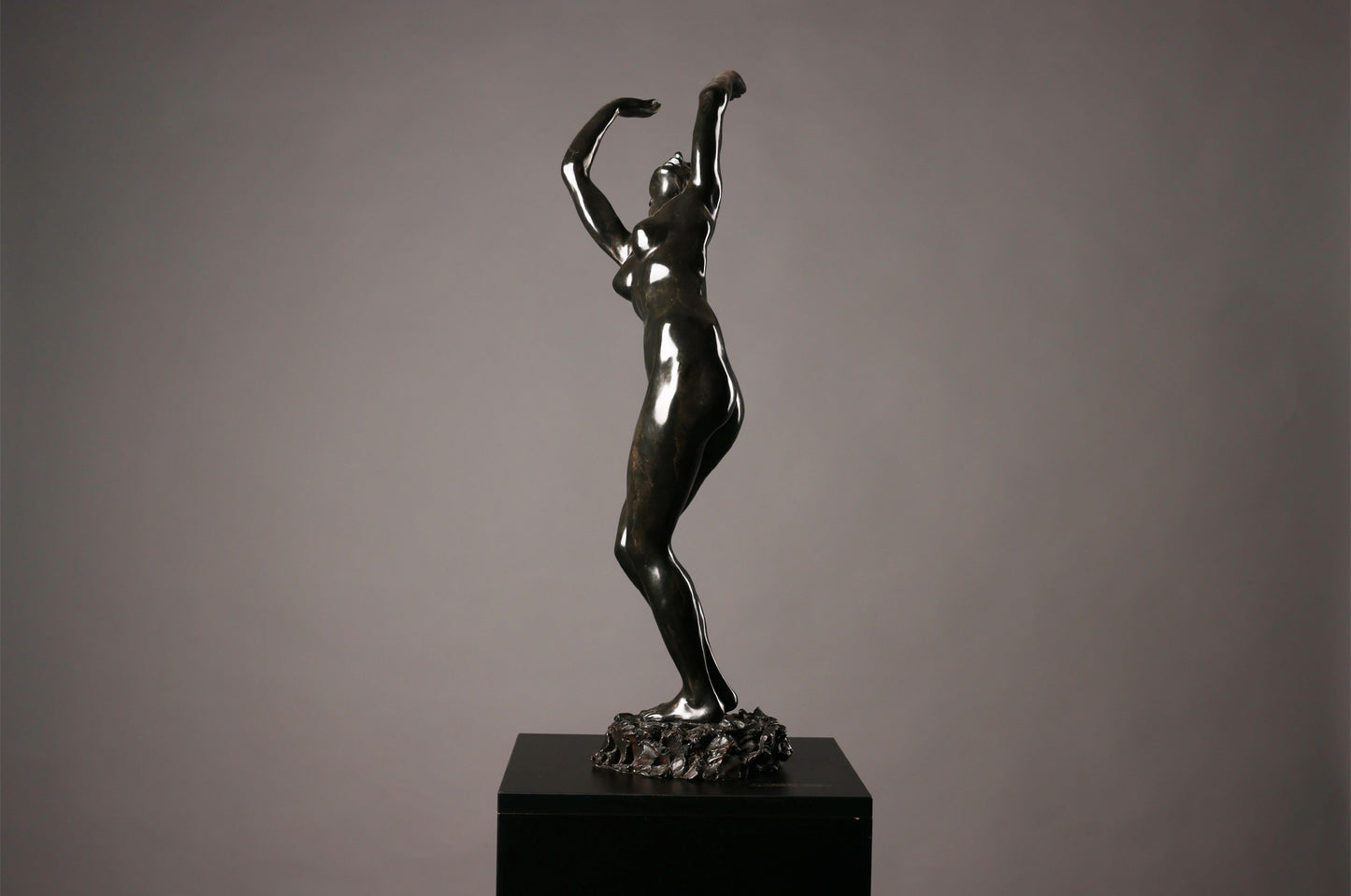 Bronze sculpture of a dancer on a gray background