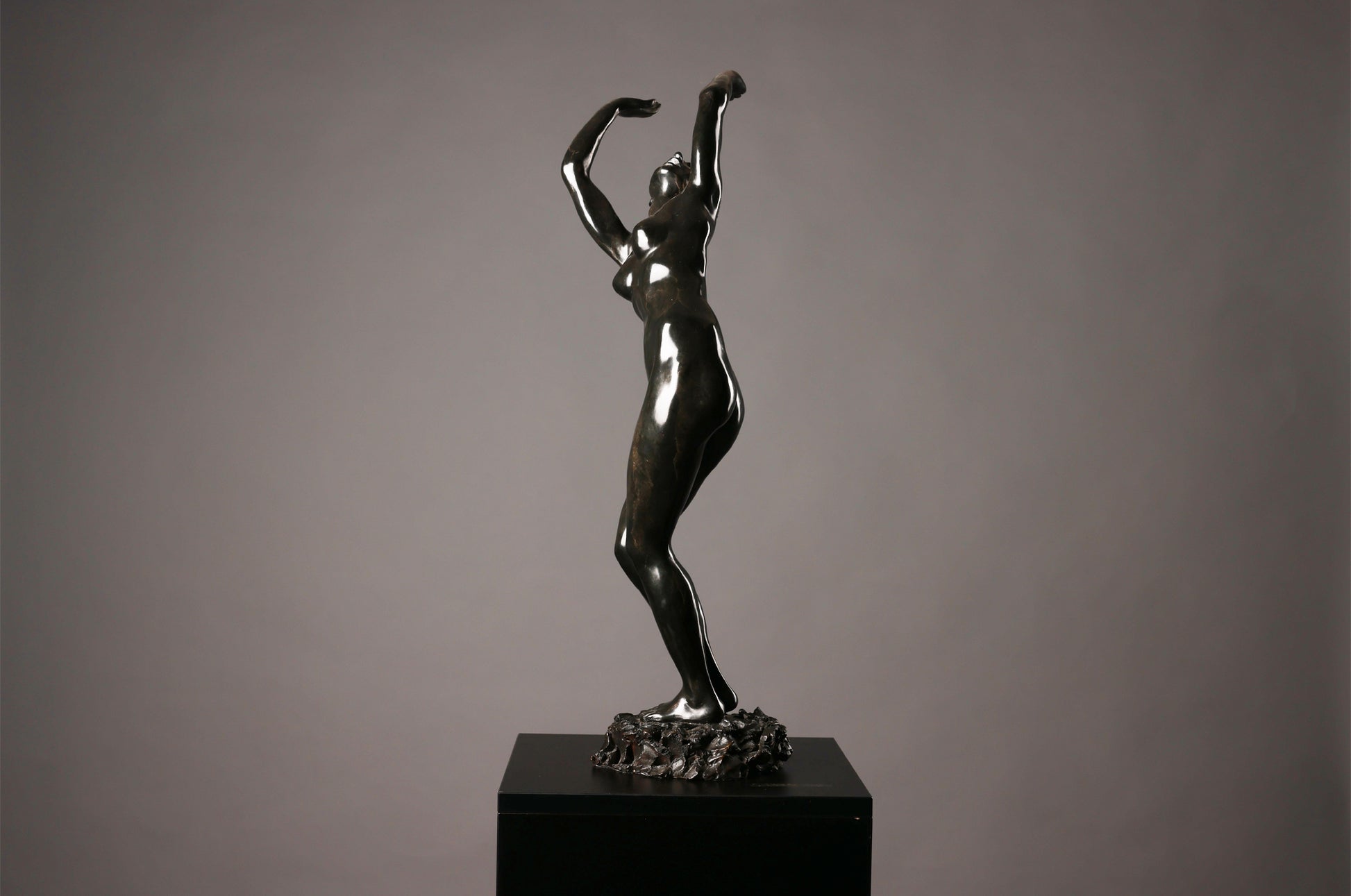 Bronze sculpture of a dancer on a gray background