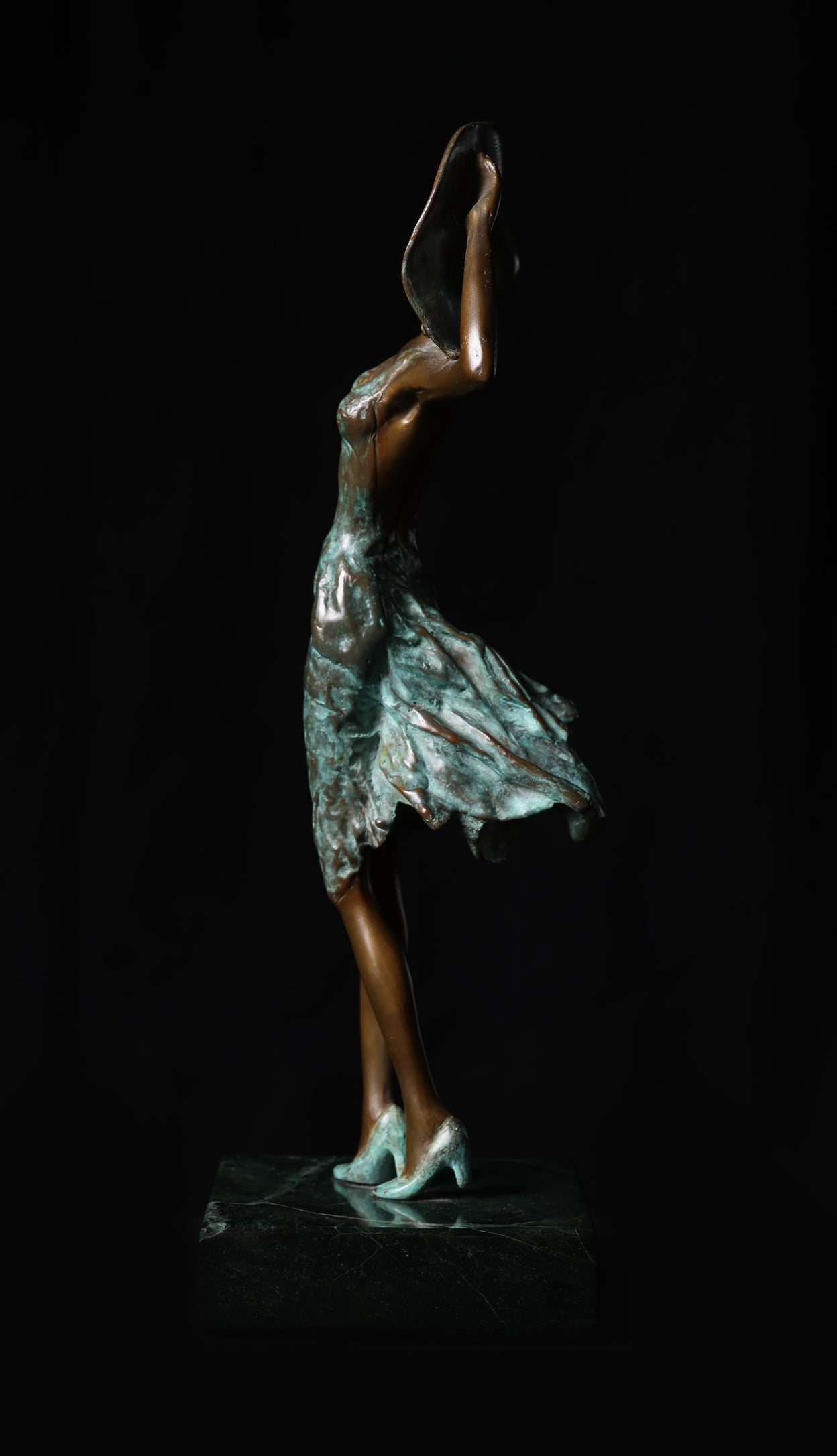Bronze sculpture of a dancer against a black background