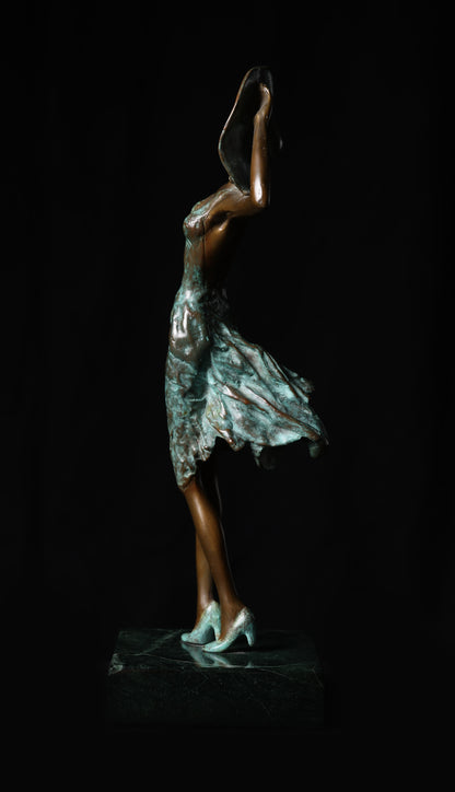 Bronze sculpture of a dancer against a black background
