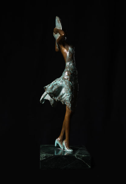 Bronze sculpture of a dancer with a silver skirt on a black background